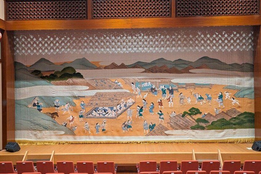Een muurschildering van een traditioneel Japans tafereel met mensen en gebouwen. 5