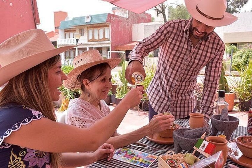 Persone impegnate in attività culinarie all'aperto, con utensili da cucina e ingredienti su un tavolo. 5
