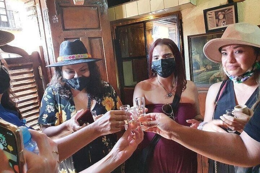 A group of people toasting with drinks in a wooden interior setting. 1