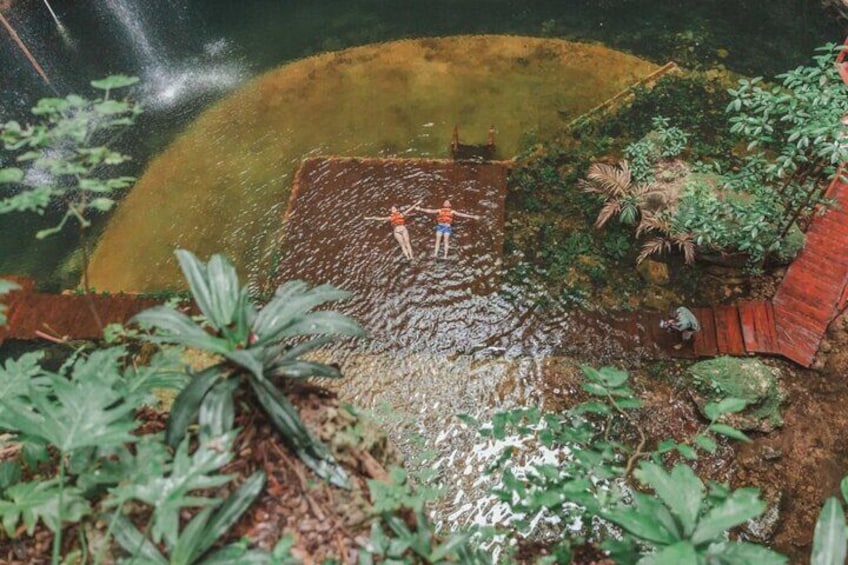Una persona in piedi su una piattaforma di legno in una distesa d'acqua, circondata dal verde. 2