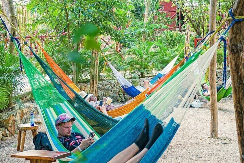 Un'amaca in un ambiente naturale verdeggiante, con persone che si rilassano. 5