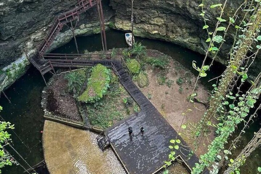 Una struttura circolare in pietra con una passerella in legno e una scala in metallo che conduce a una piccola imbarcazione. 4