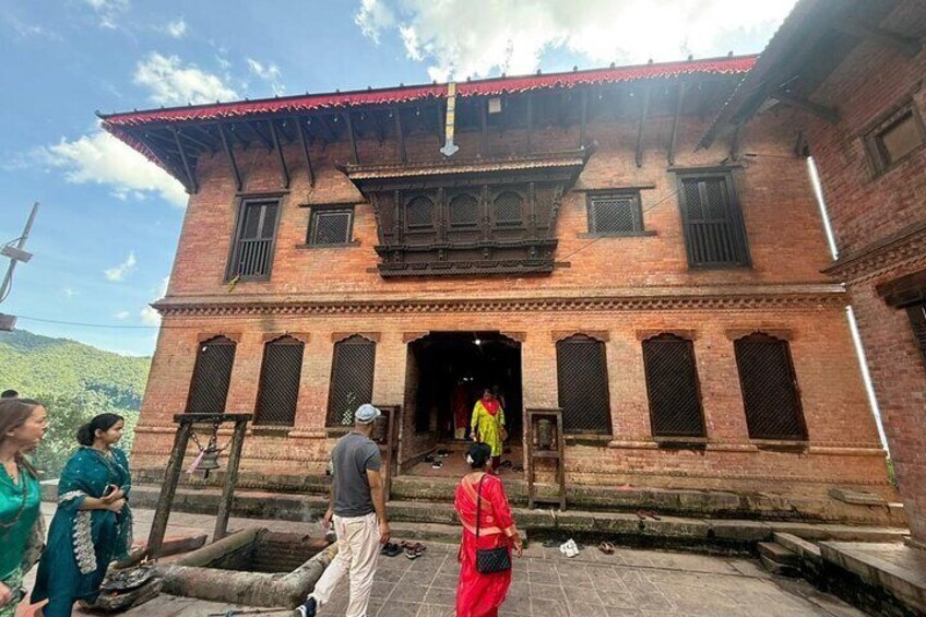 A traditional brick building with a red roof and multiple windows. 3