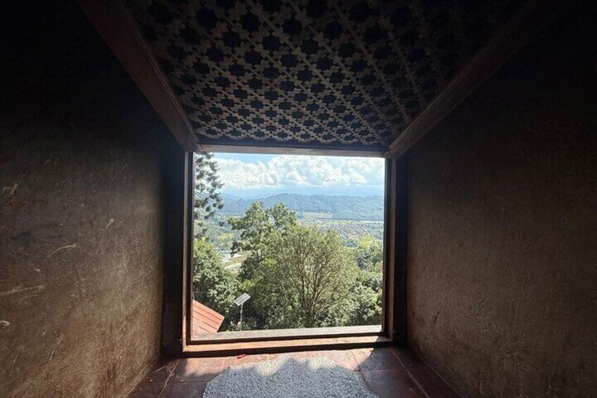 A room with a view of a landscape through a window. 5