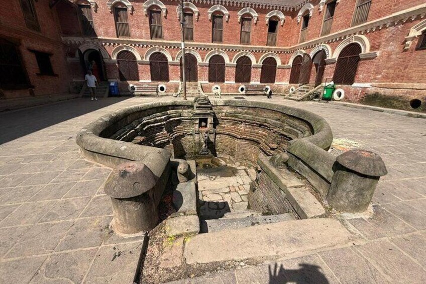 An ancient stone well surrounded by brick walls with arched windows. 4