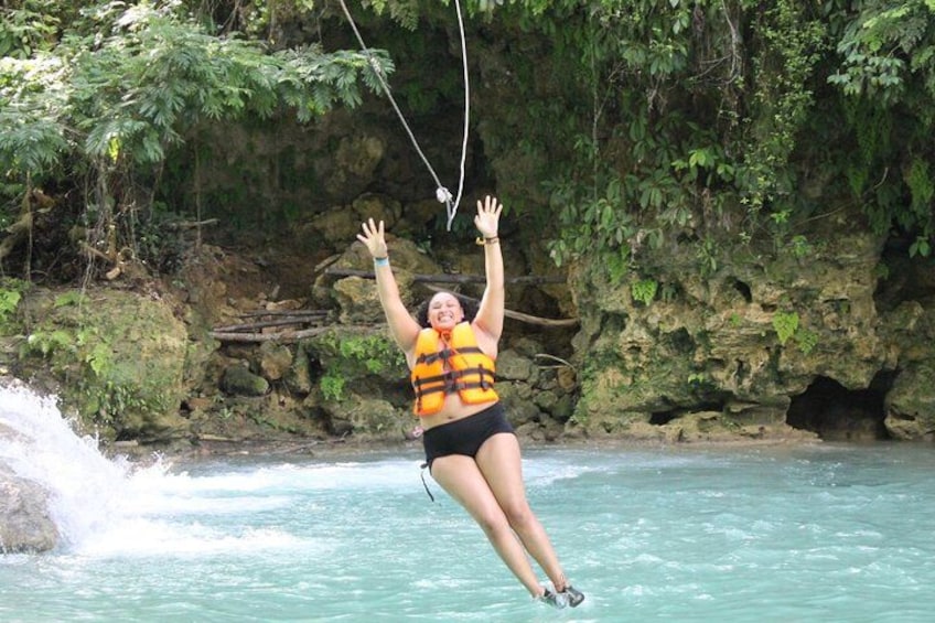 Eine Person macht Bungeesprung von einer Brücke über einem Fluss, im Hintergrund eine felsige Klippe. 3