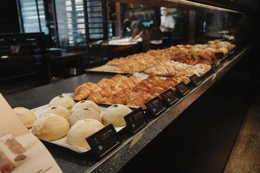 Een bakkerijdisplay met diverse gebakjes en brood. 2