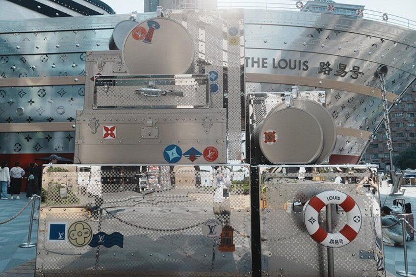 Een grote metalen constructie met de tekst 'THE LOUIS' en verschillende symbolen, waaronder een reddingsboei. 4