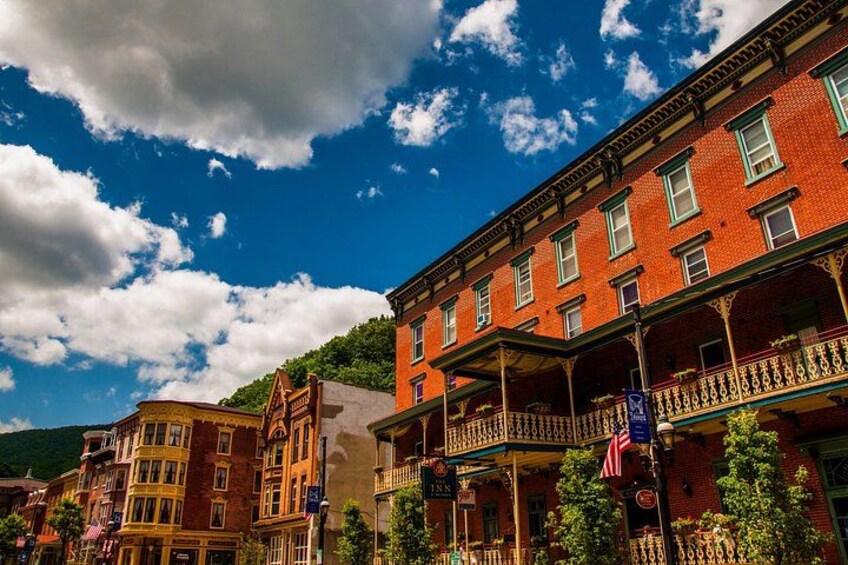 A street with historic buildings, a clear blue sky, and a flag. 2
