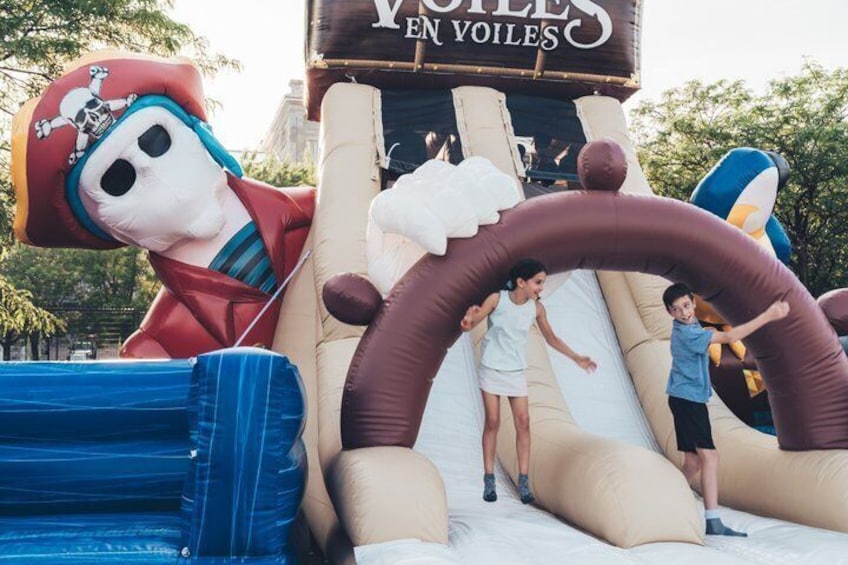 Un tobogán inflable grande con un personaje con temática pirata a la izquierda y un letrero que dice 'Y VELLES EN VOILES'. 5