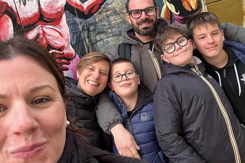 Un gruppo di persone che posa davanti a un murale. 2