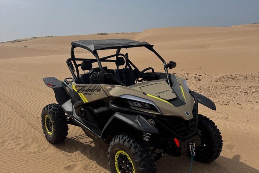 Een buggy in een woestijn, met zandduinen op de achtergrond. 2