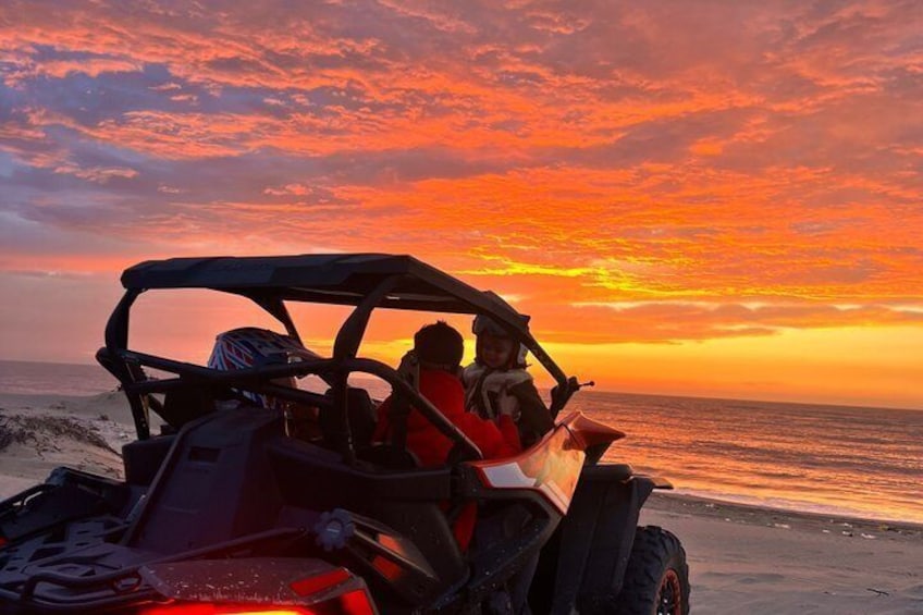 Un buggy des dunes sur une plage au coucher du soleil. 4