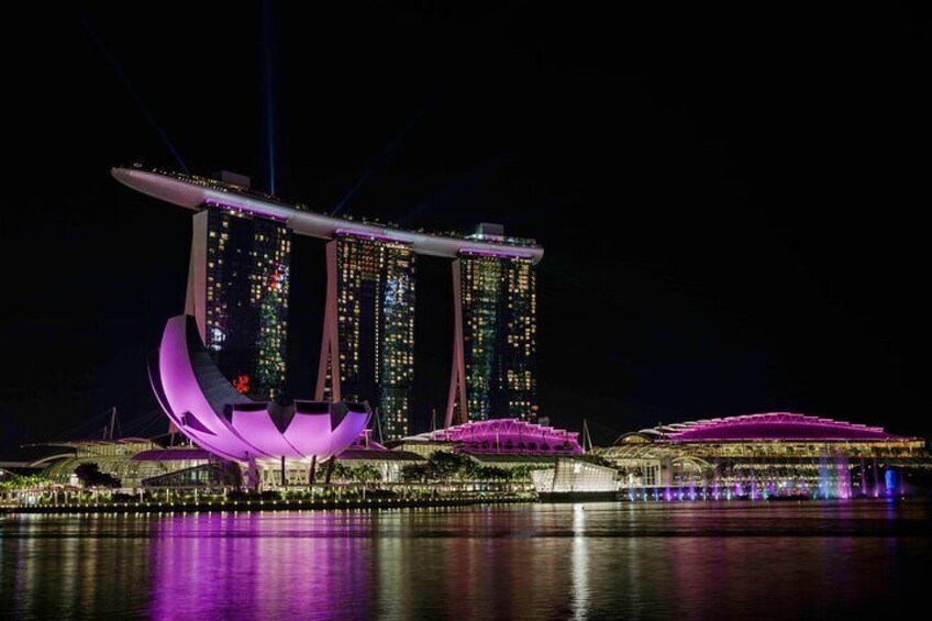 A nighttime view of Marina Bay Sands with illuminated structures and reflections on the water. 3