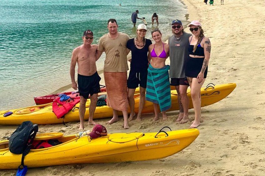 Un groupe de personnes se tient sur une plage, à côté de kayaks. 5