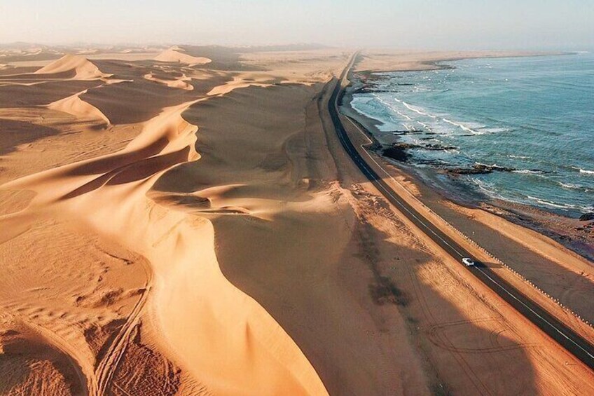 Una carretera costera con dunas de arena y el océano. 2