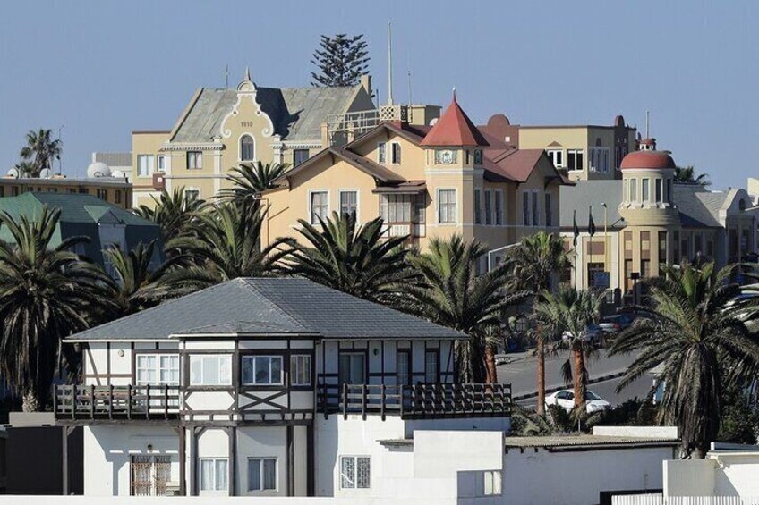 Un pueblo costero con edificios históricos, palmeras y un cielo despejado. 5