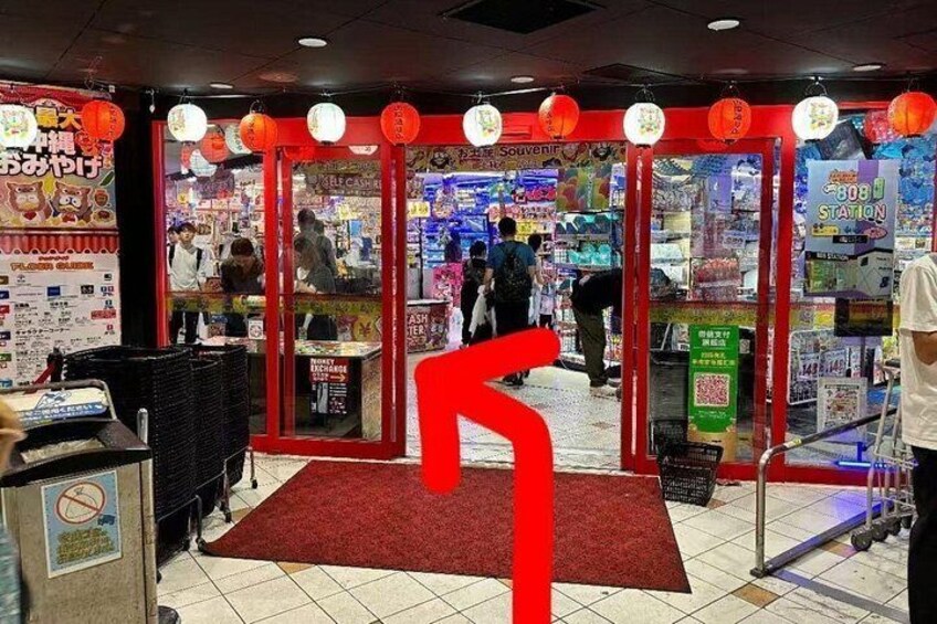 Un mercado interior bien iluminado con linternas rojas, una alfombra roja y varios puestos. 4
