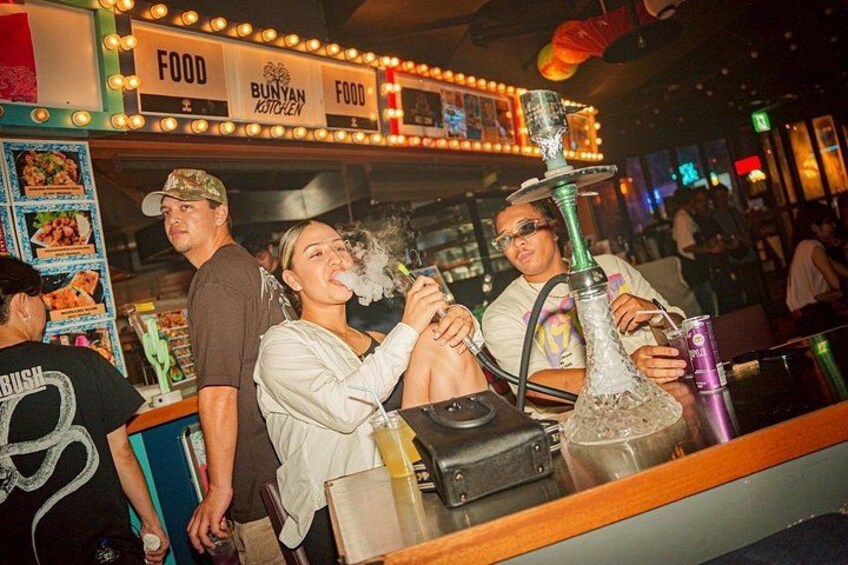 A group of people at a food stall with a hookah. 4