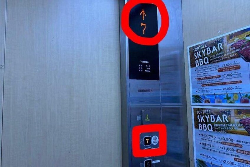 An elevator interior with a digital display, buttons, and a menu board advertising Toptree Skybar BBQ. 2