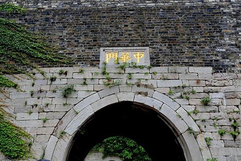 A stone archway with a sign above it. 3