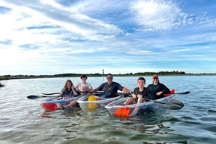 A group of people in canoes on a calm body of water with a clear sky. 5