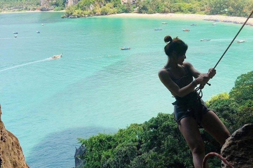 Une personne fait de la tyrolienne au-dessus d’une zone côtière, survolant une eau turquoise et des bateaux. 5