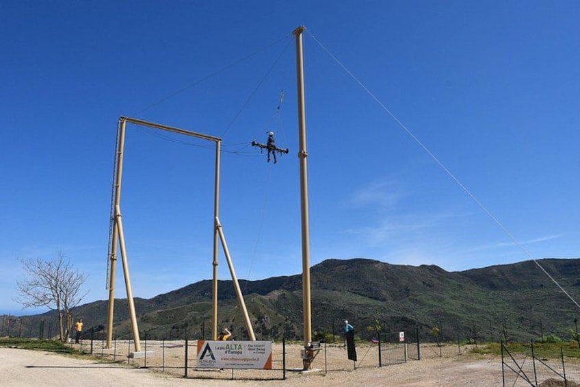 A trapeze setup with a person swinging on a trapeze. 1