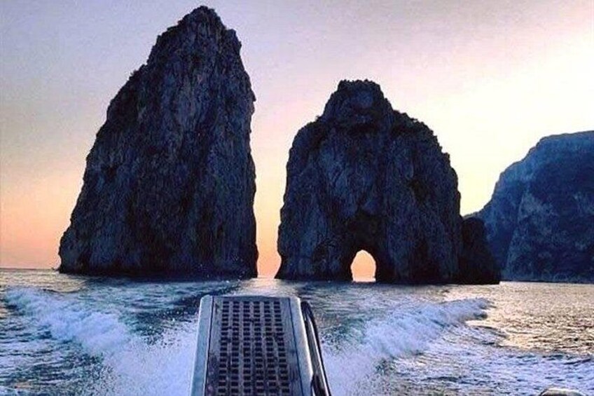 Una barca che passa attraverso un arco naturale di roccia nell'oceano. 3