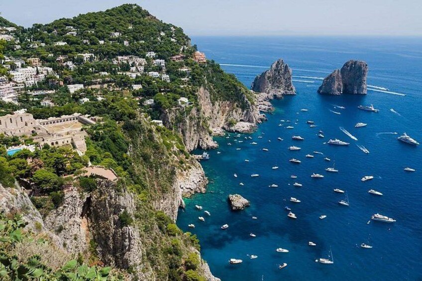 Una cittadina costiera con barche, scogliere e un edificio storico. 5