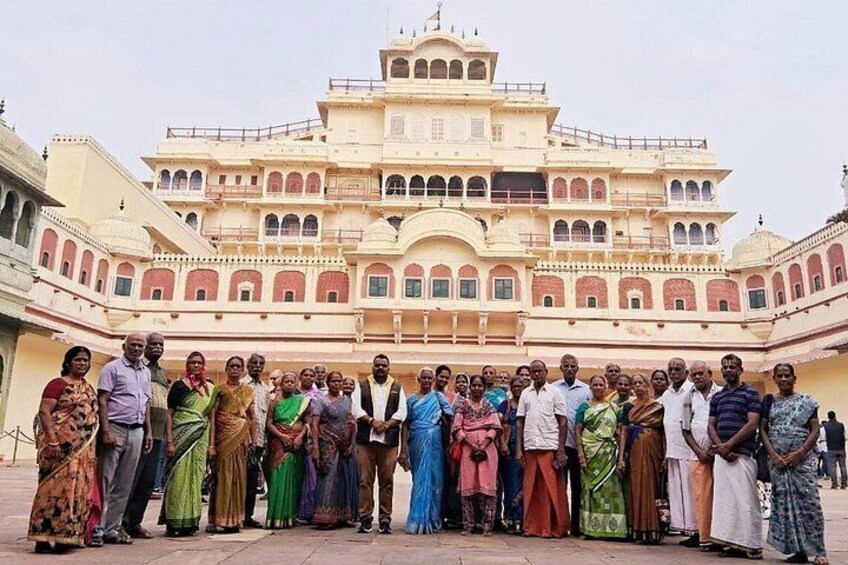 A group of people standing in front of a large, multi-tiered building with arches and domes. 4