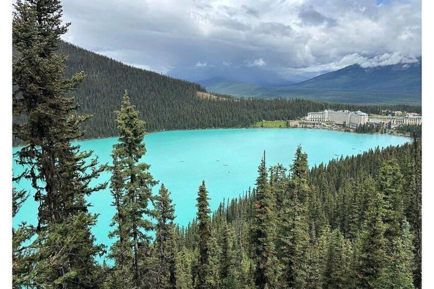 A turquoise lake surrounded by dense forests and mountains. 3