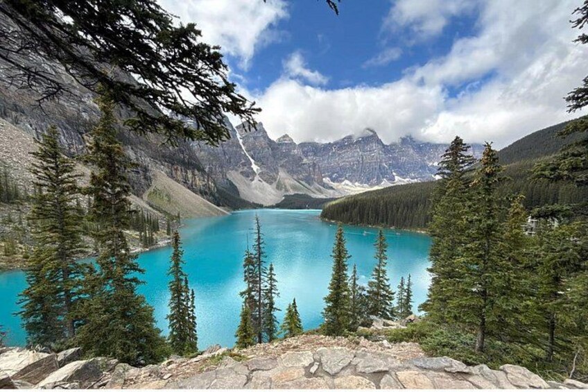 A turquoise lake surrounded by mountains and coniferous trees. 4