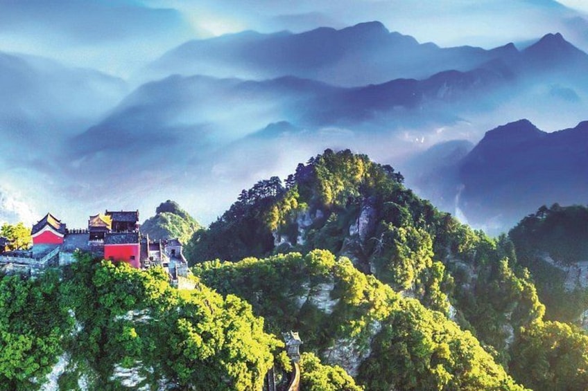 A mountainous landscape with traditional buildings and lush greenery. 1