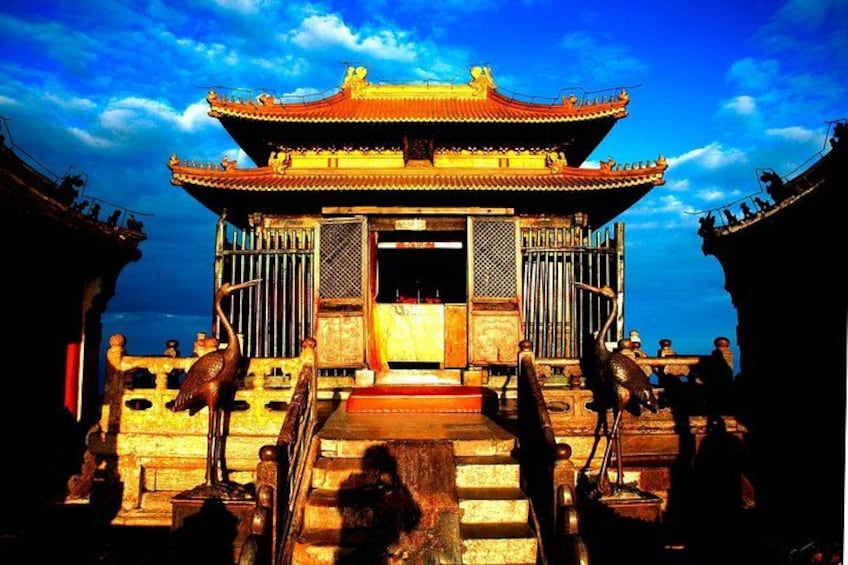 A traditional Chinese building with a tiled roof, a central entrance, and a staircase leading up to it. 2