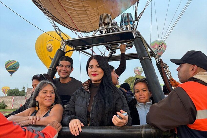 A hot air balloon with passengers and a ground crew. 1
