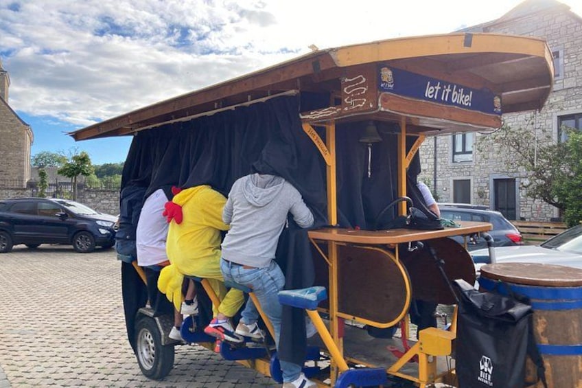 A vintage trolley with a sign that reads 'let it bike!' parked on a cobblestone street. 2