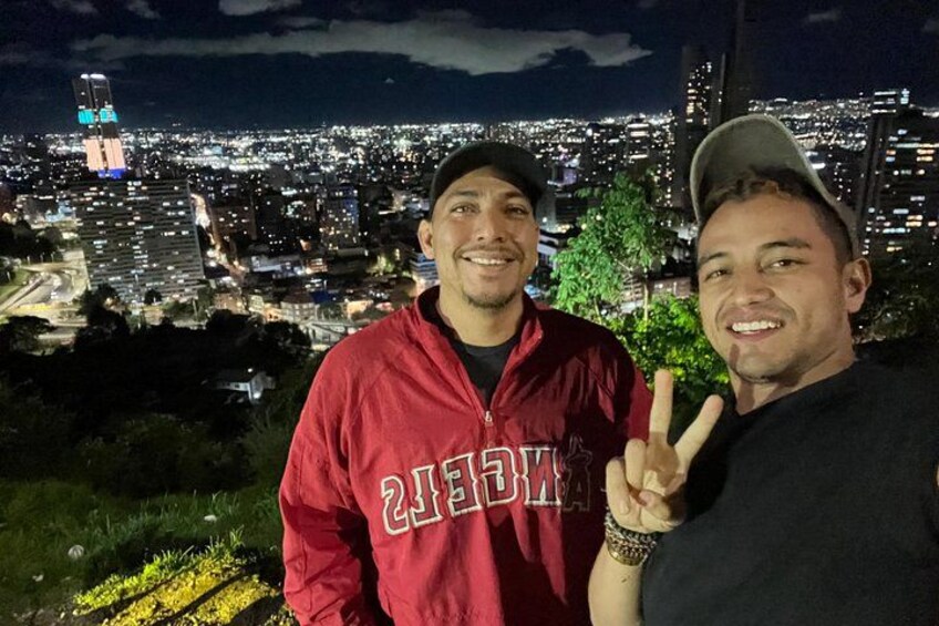 Two people standing with a cityscape in the background. 3