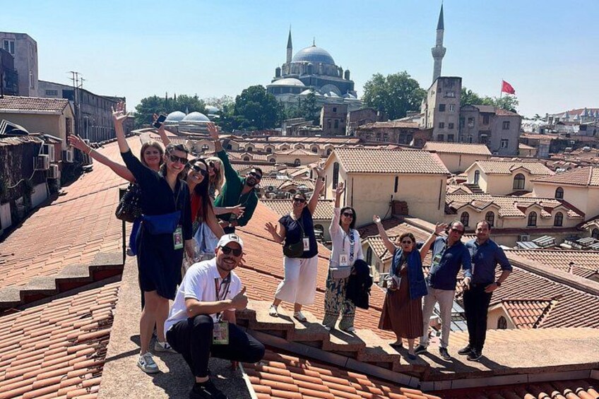 Un groupe de personnes se trouve sur un toit, avec une vue sur la ville en arrière-plan. 1