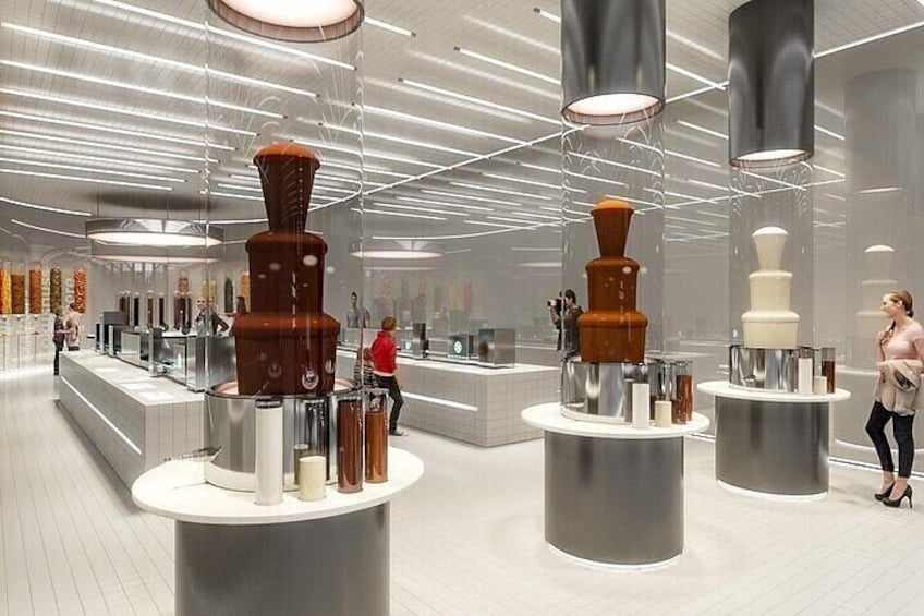 A modern interior with cylindrical structures on pedestals, glass display cases, and a reflective ceiling. 5