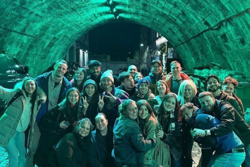 A group of people in a tunnel with green lighting. 2