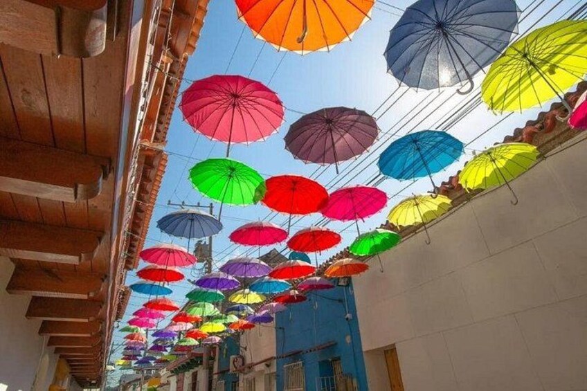 A street lined with colorful umbrellas hanging overhead. 3