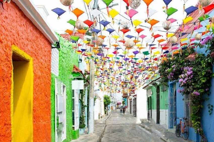 A narrow street with colorful buildings and hanging lanterns. 5