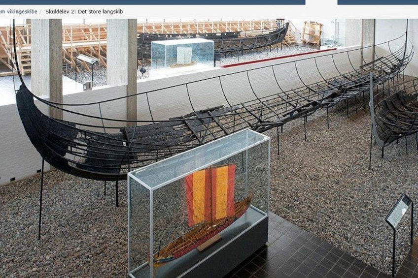 A Viking ship exhibit with a reconstructed ship and a display case with artifacts. 2