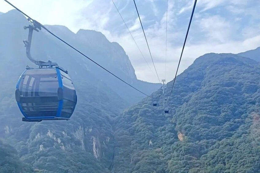 Un teleférico suspendido sobre un paisaje montañoso. 4