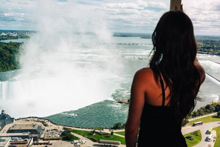 A waterfall, a body of water, and a distant cityscape. 1