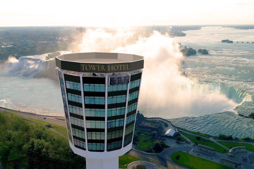 A tall hotel building with the name 'TOWER HOTEL' near a large waterfall. 2