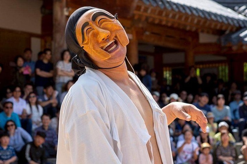 A person in traditional attire standing in front of an audience. 2