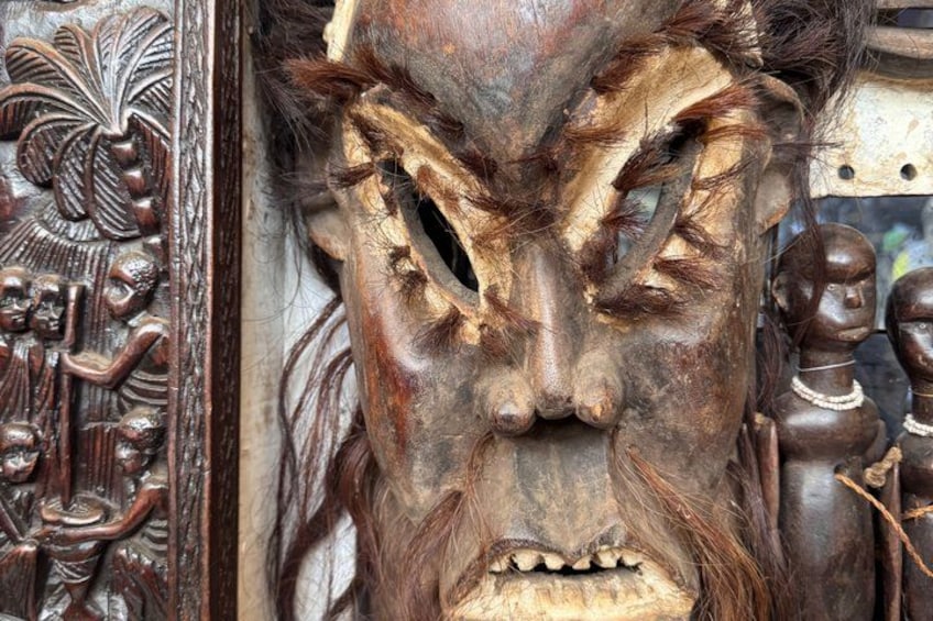 A wooden carving with intricate details and a figure holding a staff. 2