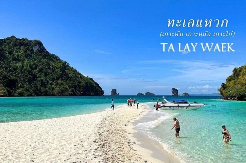 A beach with clear turquoise water, white sand, and a boat in the distance. 4